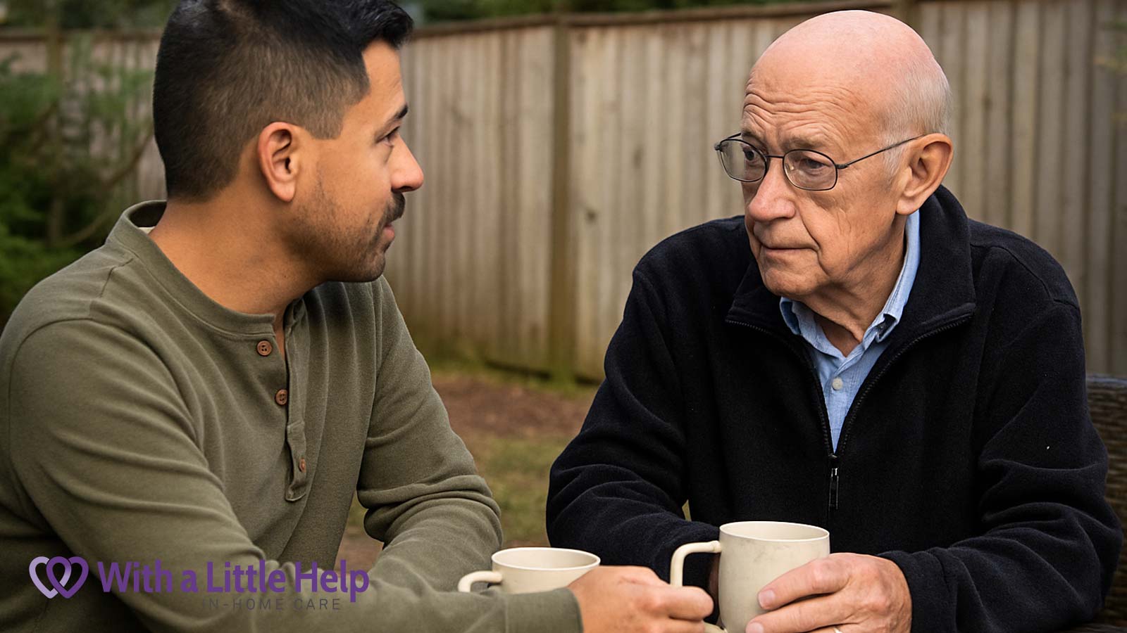 Senior caregiving at home — a Hispanic male caregiver and older white man share a quiet moment together in a backyard over tea.