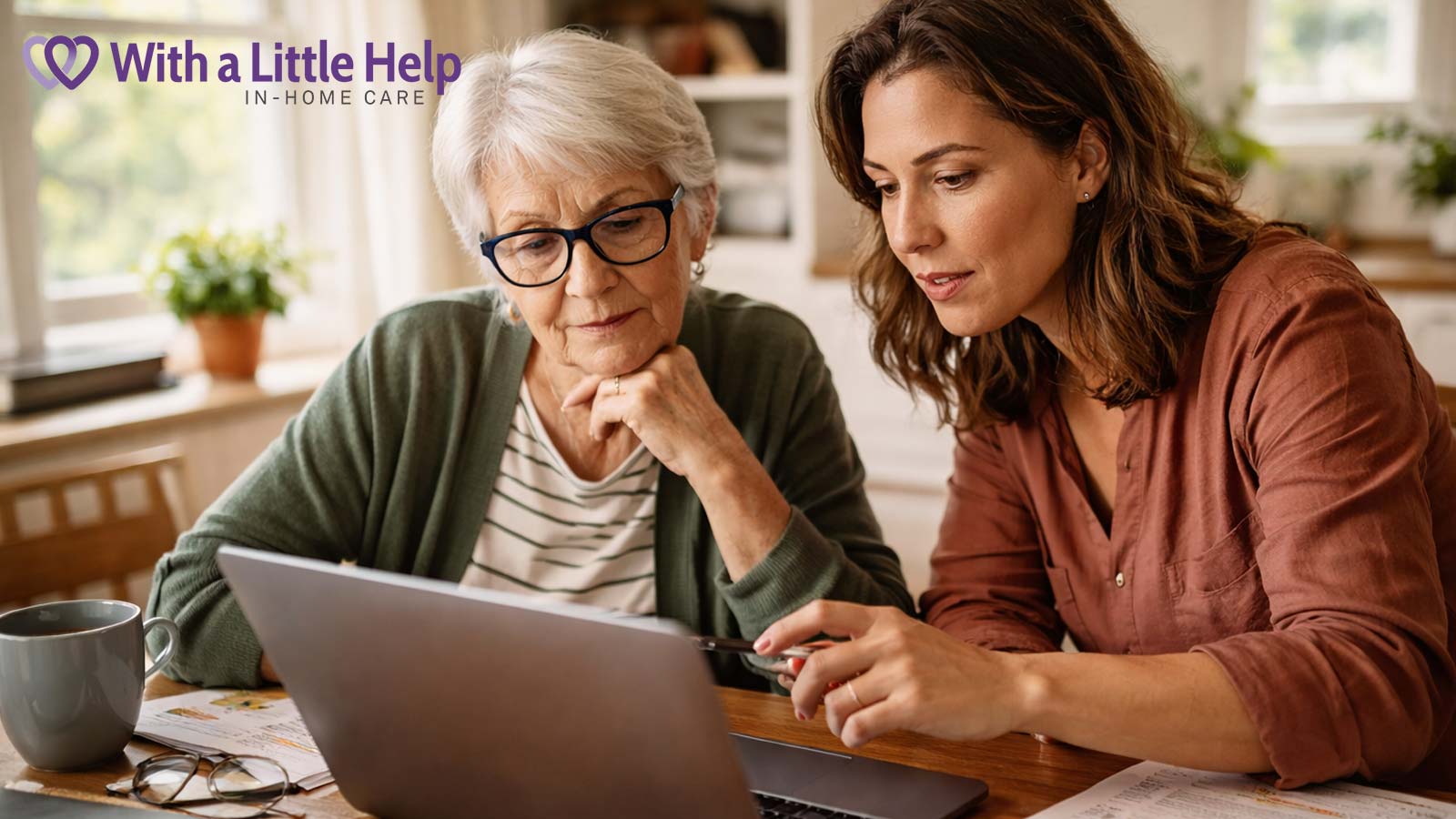 Adult daughter helping her elderly mother research in-home care options on a laptop at the kitchen table.
