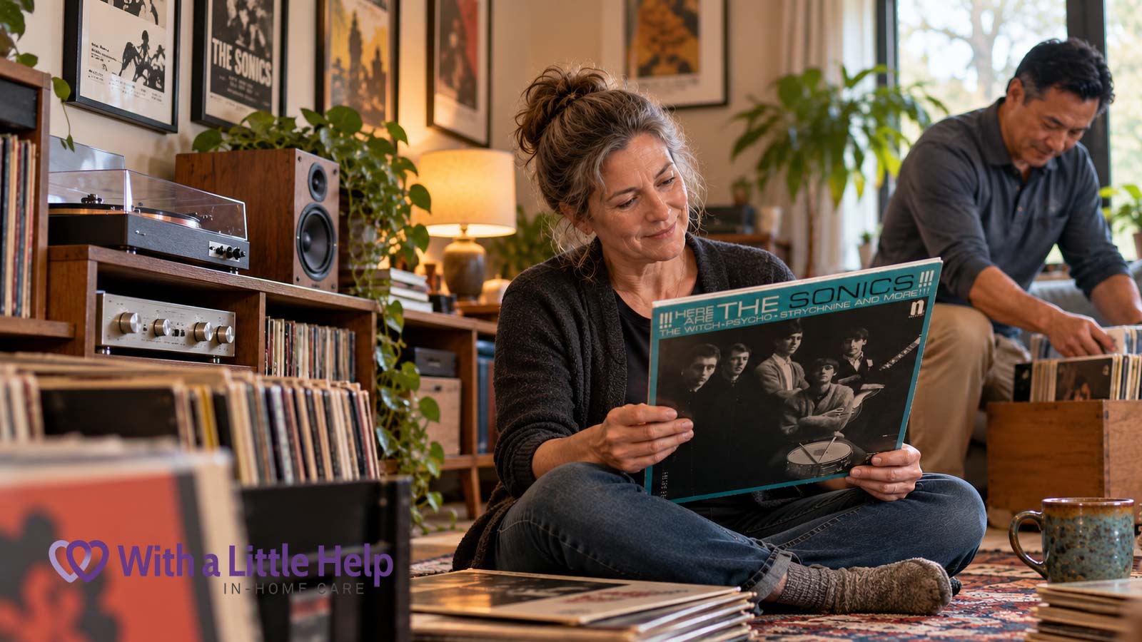 In-home care for adults in Seattle helps a woman enjoy her vinyl record collection while a caregiver organizes heavy boxes of records.
