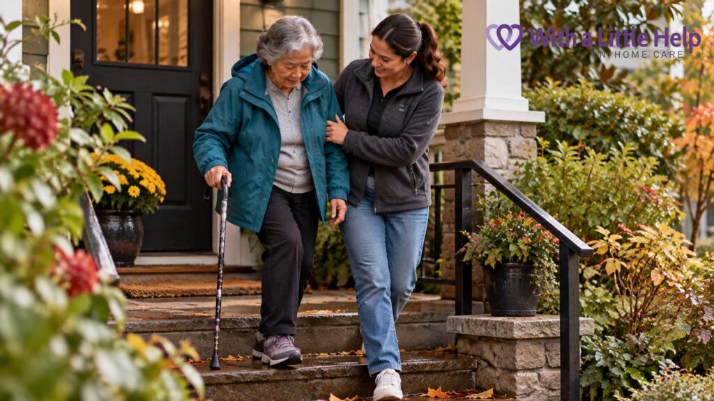 An elderly Asian woman uses a cane while a caregiver helps her navigate outdoor steps, illustrating physical therapy at home for seniors in Seattle.